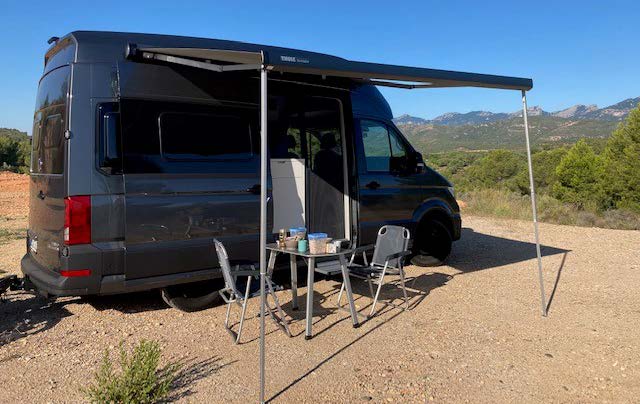 VW Grand California 600 rechts mit Markise und Campingmöbel